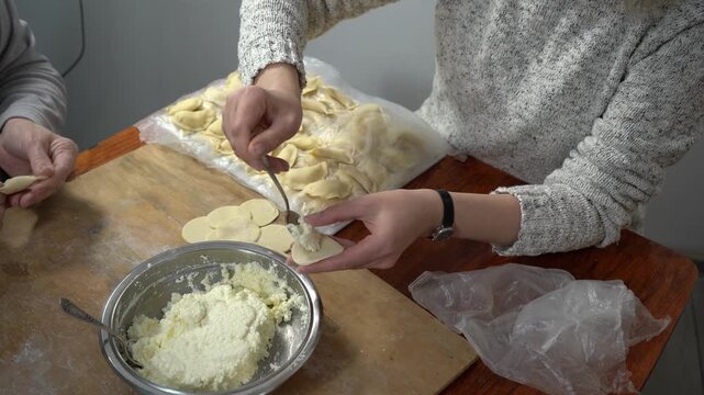 Hands making cottage cheese dumplings. Cook dough food at home.