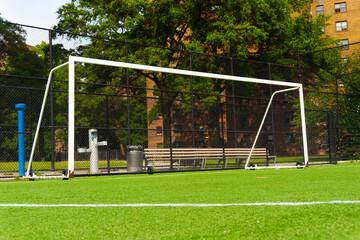 A serene soccer field with a goal post on green grass in an urban setting.  © kareem