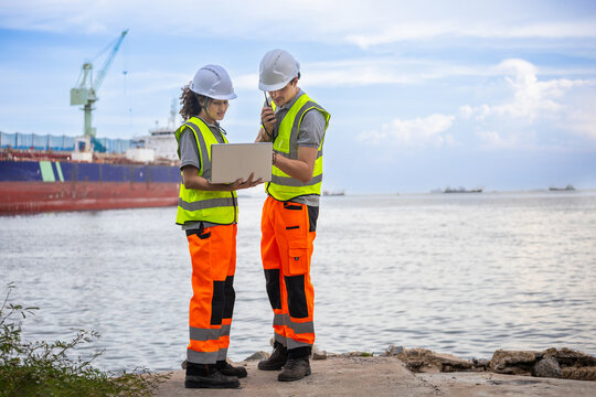 Logistics engineers using laptop and radio at cargo shipping port, Port workers inspecting shipping operations at terminal, Team of marine logistics specialists managing freight transport at harbor