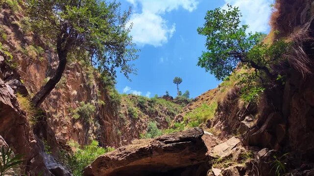 Stunning view of small winding roads weaving through Najigram Dara&rsquo;s greenery, flanked by towering mountains on both sides.