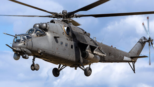 Military helicopter flies above the ground during a training mission in clear sky