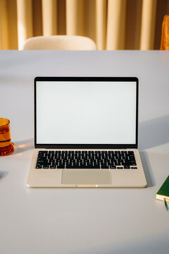 A laptop with a white screen on a desk
