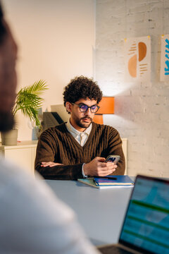 A man uses a mobile phone during an office meeting