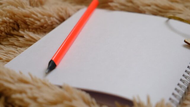 Empty sketchbook opened on terry beige carpet. Blank notepad, empty page, place for text. New year's goals notebook.  Empty space for text.