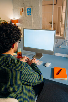 A man uses a computer with a white screen 