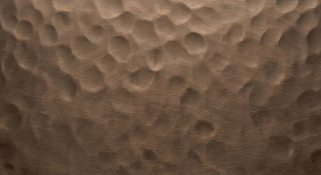 Hand hammered matte bronze metal texture with wabi sabi dimples