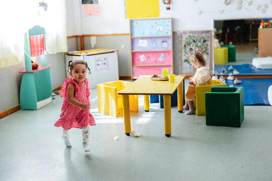 Happy young child walking inside a modern kindergarten