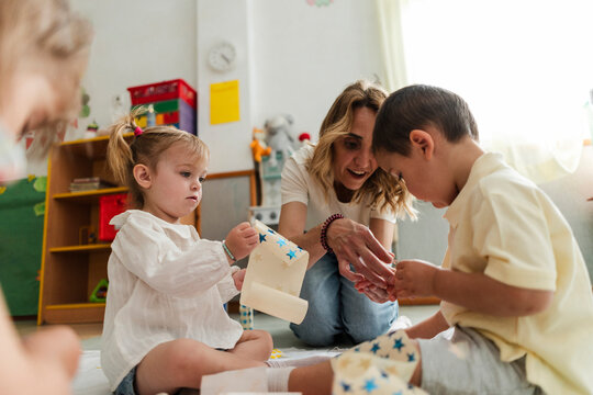 Teacher engaging young children in creative classroom activity