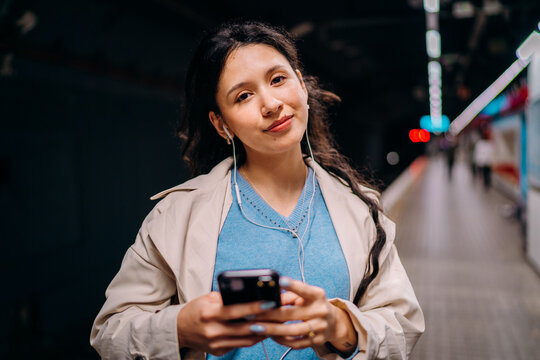 A woman standing on a subway platform.