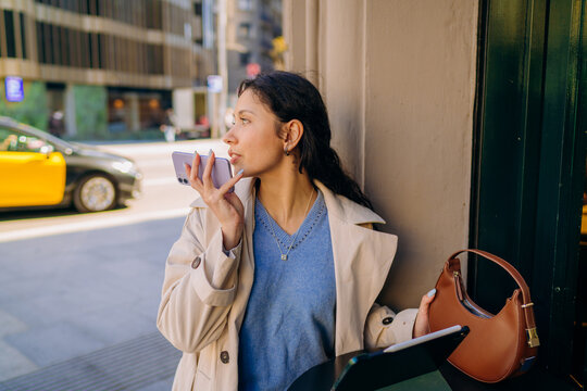 A woman using a tablet in the city