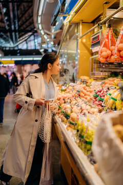 A woman buys fruits at the market