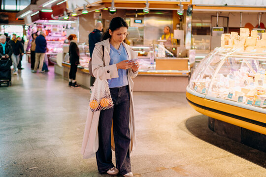 A woman using a mobile phone in the market