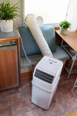 Portable air conditioner unit operating inside a modern camper van during a summer heatwave