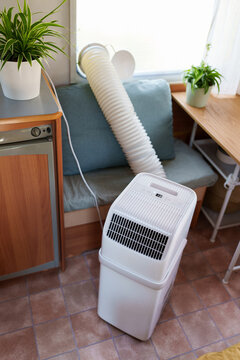 Portable air conditioner unit operating inside a modern camper van during a summer heatwave