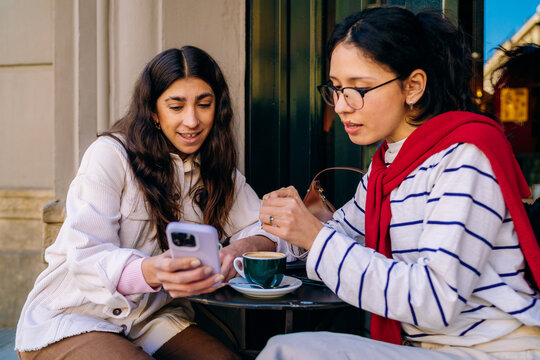Two women using a mobile phone in a cafe