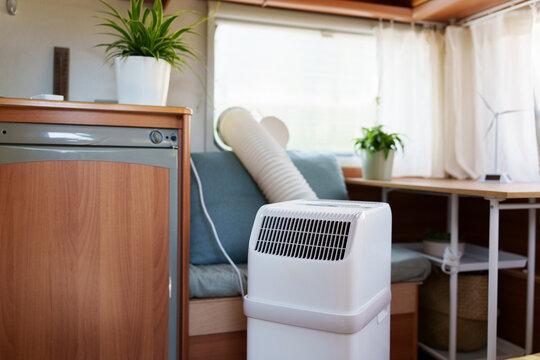 Portable air conditioner unit operating inside a modern camper van during a summer heatwave