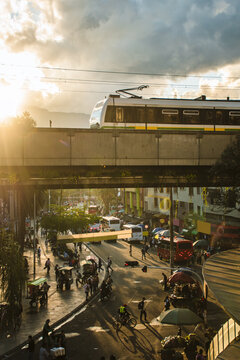 Elevated Medell&iacute;n Metro Above a Busy Downtown Street at Sunset