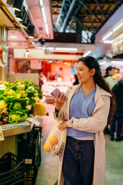 A woman buys vegetables at the market