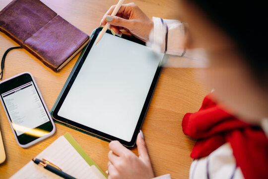 A woman using a tablet with a white screen