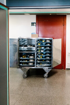 A metal cart with food trays in a hospital hallway