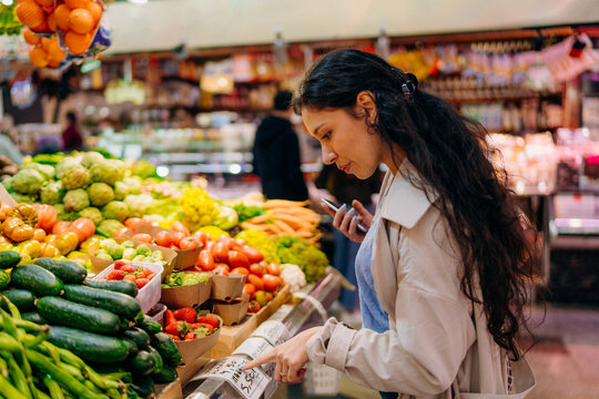 A woman buys vegetables at the market