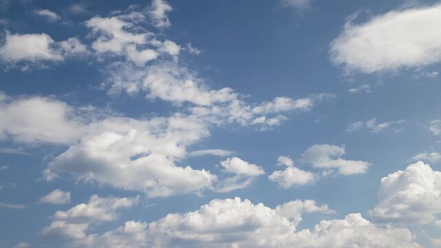 Cinematic time-lapse capturing dynamic layers of clouds, where some white clouds drift across the frame while others actively form and expand in place against a bright blue sky background.