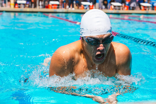 man swimming breastroke in race pool 
