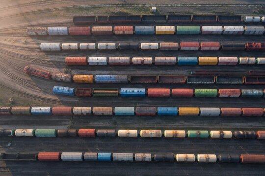 Aerial view of a railway marshalling yard with colorful carriages in rows.