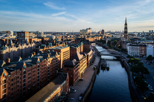 Aerial view of the historic Speicherstadt warehouse district with its iconic red-brick architecture, canals, and bridges under a clear sky in Hamburg, Hamburg, Germany.