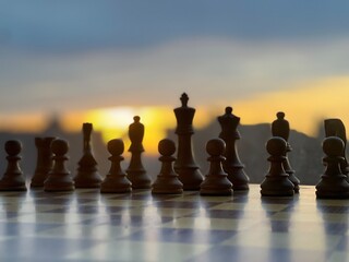 Silhouette of chess pieces on a board with a cityscape at dusk, evoking a sense of strategy and focus.  © kareem