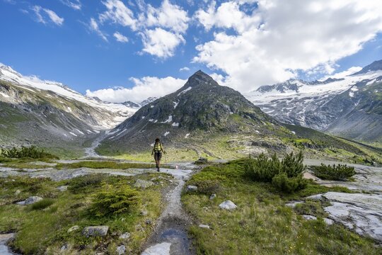 Mountaineer on hiking trail in front of picturesque mountain scenery, in the background mountain peak Steinmandl with glacier Waxeggkees and glacier Hornkees, Berliner H&ouml;henweg, Zillertal Alps, Tyrol, Austria