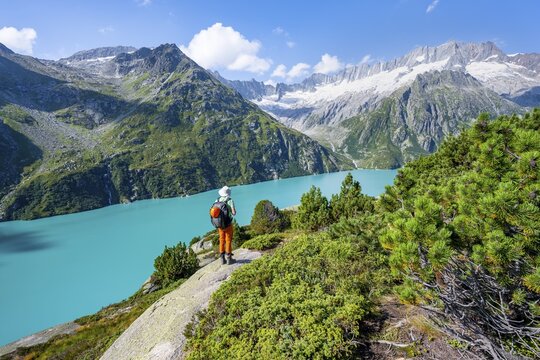 Mountaineers in front of picturesque mountain landscape, turquoise-blue mountain lake G&ouml;scheneralpsee, Dammastock and Damma Glacier, G&ouml;scheneralp, Canton of Uri, Switzerland