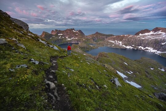 Sunset with dramatic clouds, hiker on hike to Hermannsdalstinden, lakes Krokvatnet and Tennesvatnet, mountains, Moskenes&oslash;ya, Lofoten, Nordland, Norway
