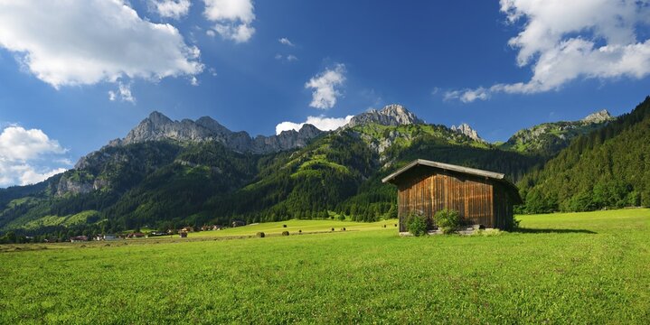 Typical landscape in the Alps, green meadows, haystacks and mountains in the Tannheimer Valley, Tyrol, Austria