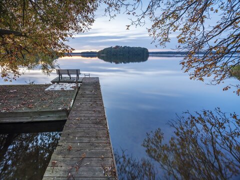 Quiet lake in autumn after sunset at dusk, colorful foliage lying on a jetty, Gro&szlig;er Lychensee, Lychen, Brandenburg, Germany