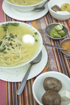 Sopa de gallina with egg, chicken soup, traditional dish in the Andean highlands of Peru, with lime, boiled potatoes, fresh cheese and aj&iacute;, La Oroya, Peru