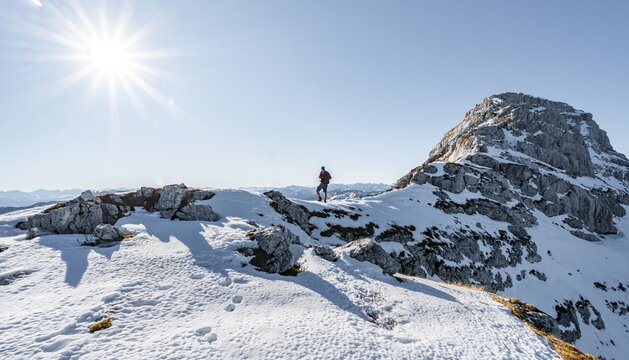 Climbers on the rocky summit ridge with first snow in autumn, hiking trail to Guffert, solar reflex, Brandenberg Alps, Tyrol, Austria
