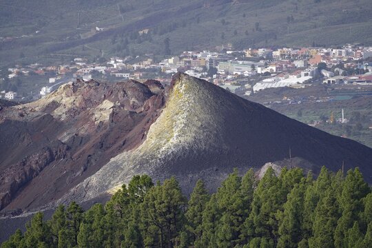 Volcanic ash cone above a cityscape, surrounded by green vegetation, last volcanic eruption of Cumbre Vieja, Todoque, La Palma, Canary Islands, Spain