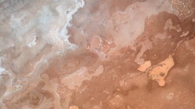 Aerial view of the salt-crusted surface of a dry lake bed with intricate patterns and textures in Norseman, Western Australia, Australia.
