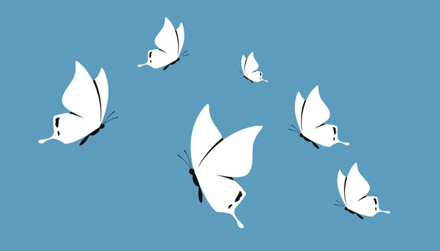 Group of white butterflies gracefully fluttering against a light blue sky background creating a sense of nature and freedom.