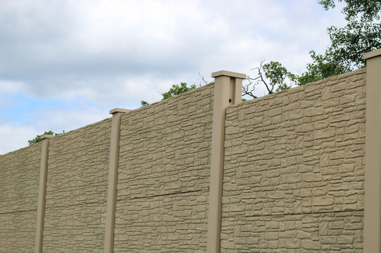 View of large precast fence panels installed by a highway entrance. Infrastructure background.