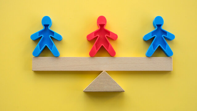 Corporate arbitrage and mediator concept featuring a red figure balancing two blue figures on a wooden scale