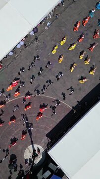 Aerial drone view of an overhead view of folk dancers and fair tents during the Feria de San Marcos in Aguascalientes, Mexico.