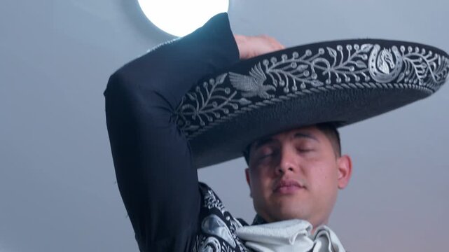 Mexican mariachi musician putting on sombrero hat