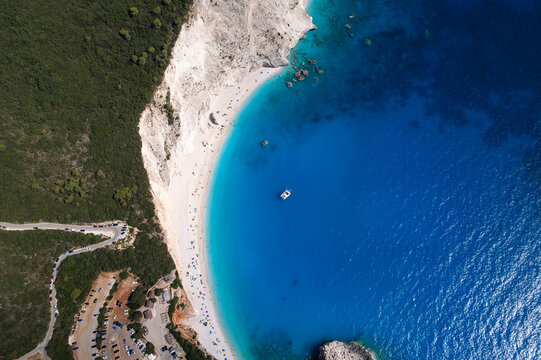 Aerial view of Porto Katsiki beach with turquoise waters, white cliffs, and a small boat in Lefkada, Greece.