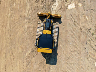 Top Down Aerial View Of Yellow Bulldozer Crawler Tractor On Graded Dirt Staging Area © Oak City Drone