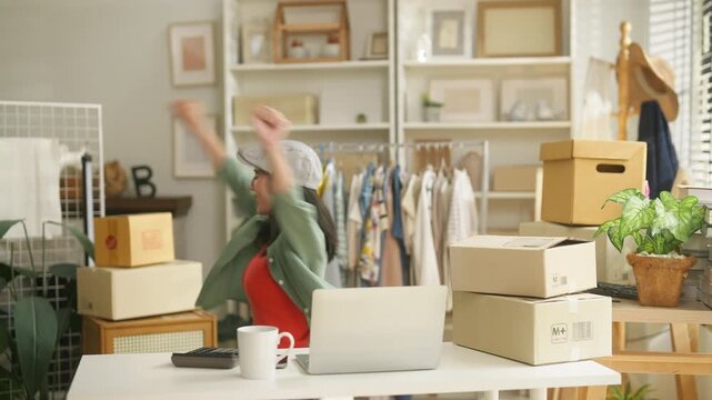 Happy Asian woman entrepreneur stretching arms at desk, online retail e-commerce merchant taking break from laptop, small business owner mental health wellbeing and work life balance concept