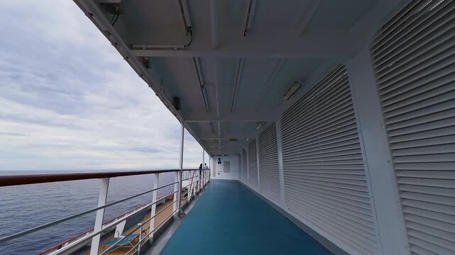 POV walking along the open promenade deck of a cruise ship at sea