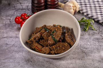 Fototapeta premium Savory stir fried meat with garlic, chili, and herbs in a bowl