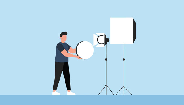 Photographer adjusting a softbox light and a reflector in a professional photography studio setting for a shoot session.